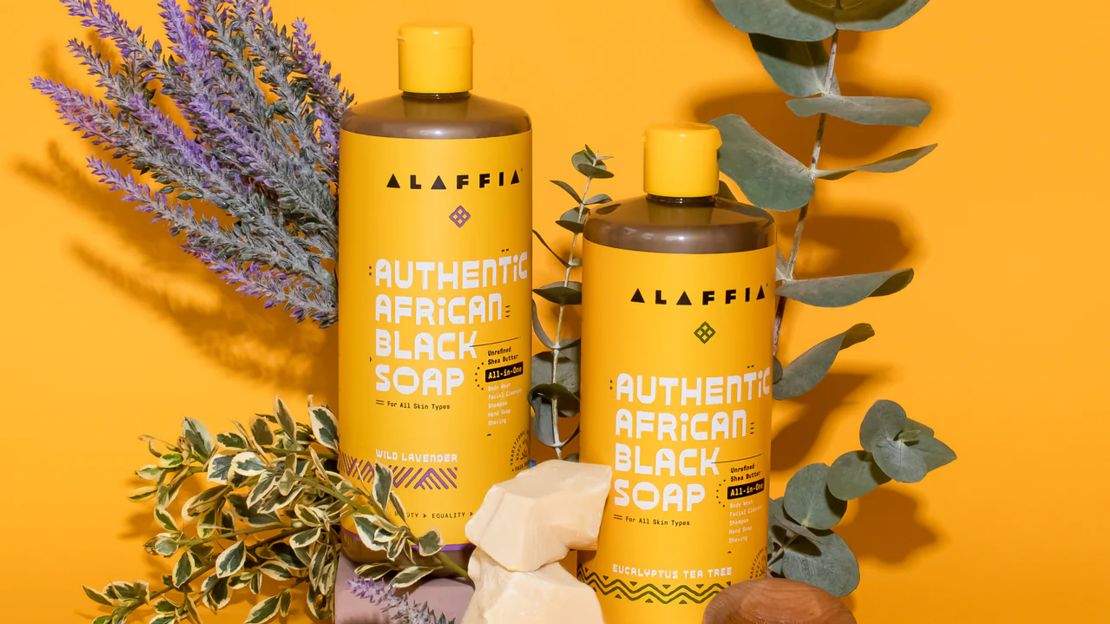 Two bottle of Alaffia African Black Soap against a yellow-orange background