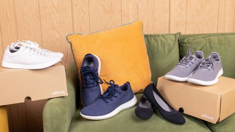 Four pairs of Allbirds shoes on couch.