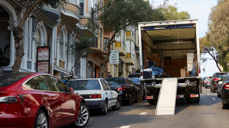 A moving truck parked in the street, ready to unload its contents.