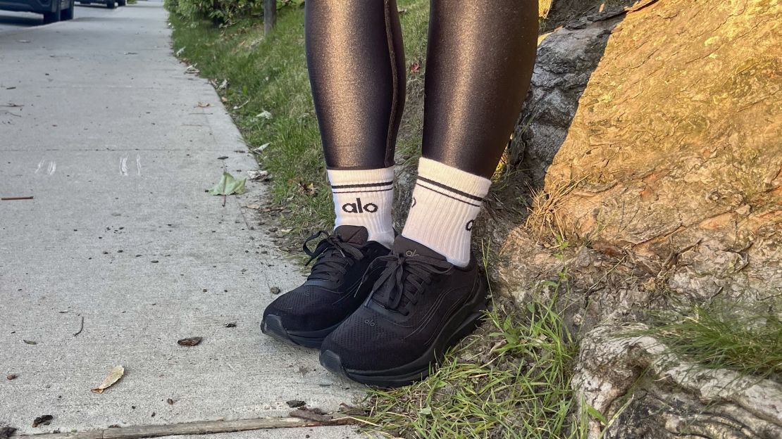 Person wearing black Alo Runner shoes with Alo socks.