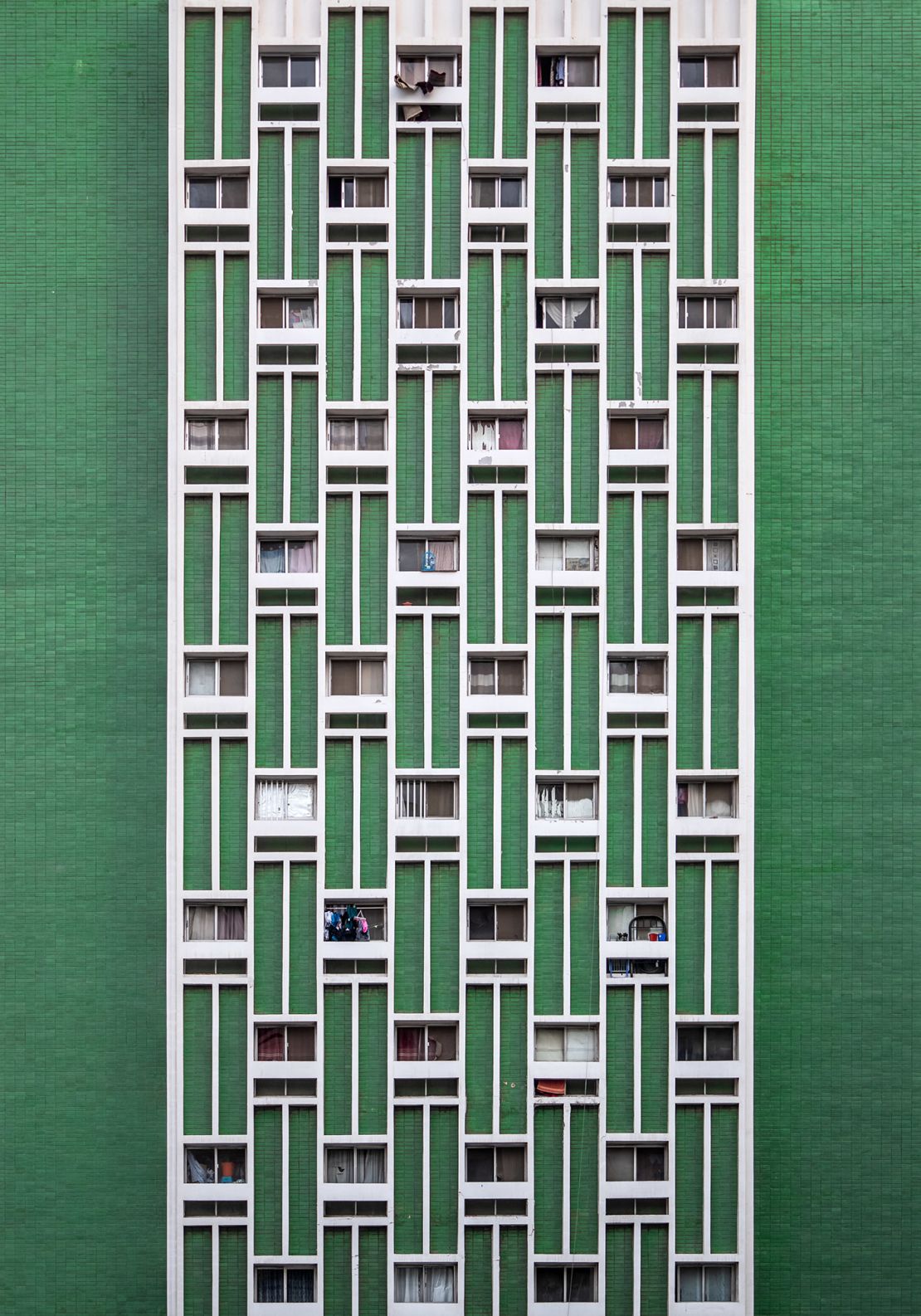 The AlOmaira Building, built in the 1980s, has a minimalist, modern facade that hides sunken windows between protruding rectangles to provide privacy and shade.