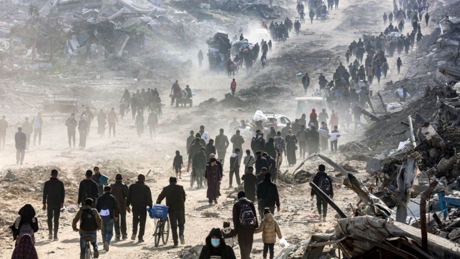 Personas caminan junto a los escombros de edificios colapsados a lo largo de la calle Saftawi en Jabalia, en el norte de Gaza, el 20 de enero de 2025, un día después de que entrara en vigor un acuerdo de alto el fuego en la guerra entre Israel y Hamas.