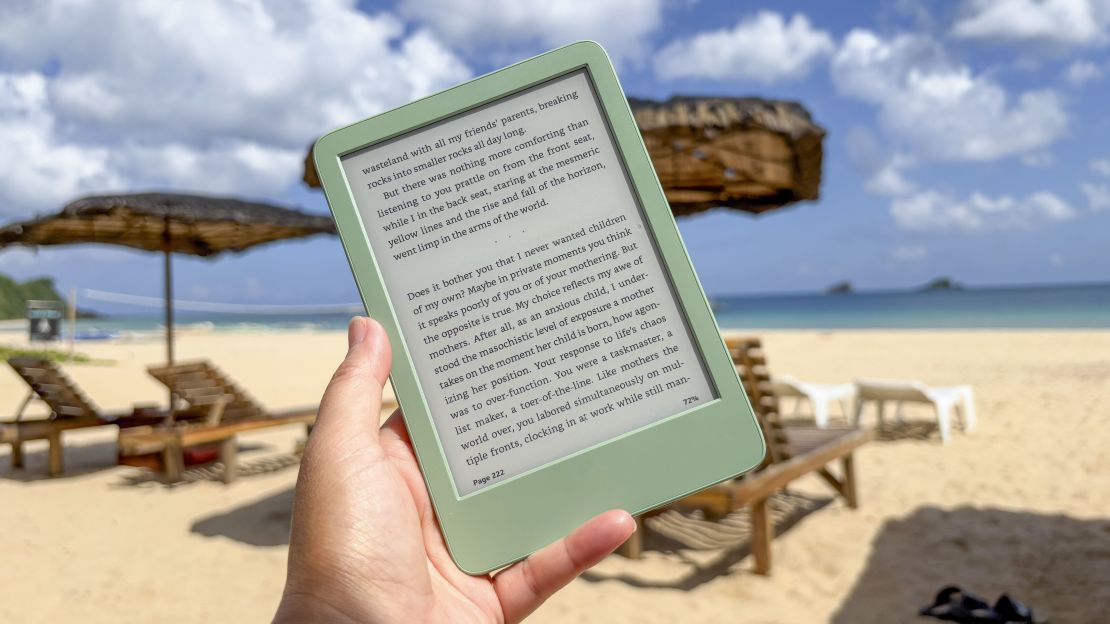 The Amazon Kindle being held by the writer with Siargao's Nacpan beach in the background