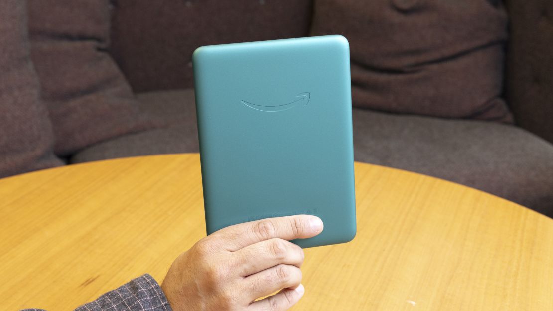 The Jade green Amazon Kindle Paperwhite Signature Edition seen from the back, held in the air