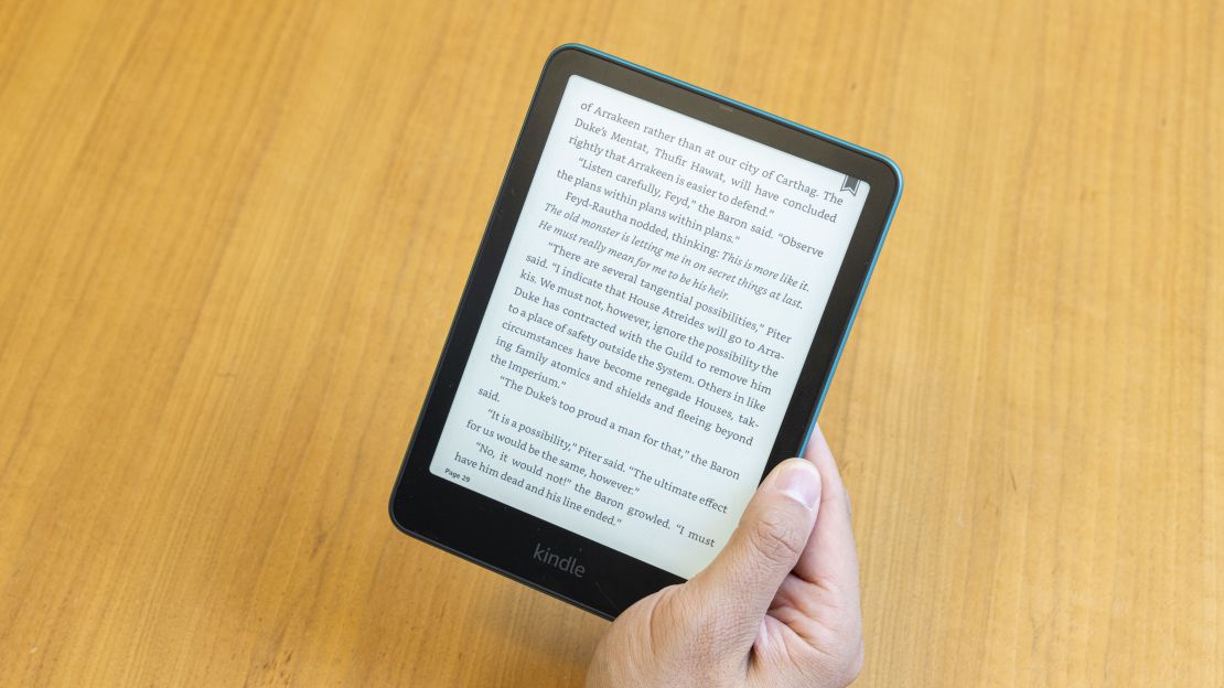 A hand holds the Amazon Kindle Paperwhite open to a page from Dune