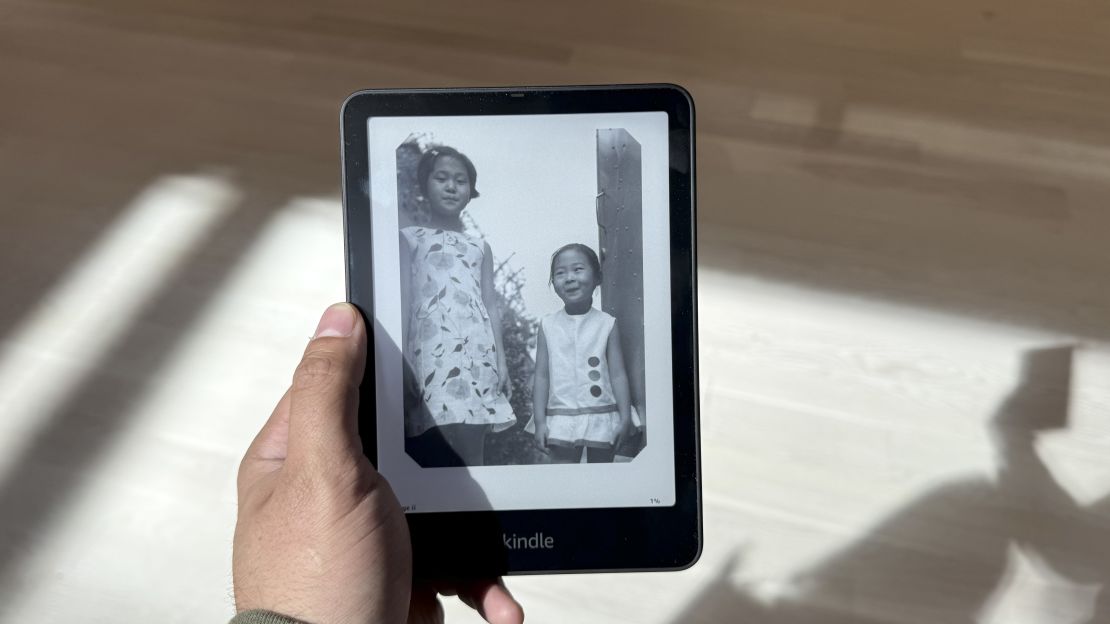 Amazon Kindle Colorsoft held up to a black and white photo of two young children