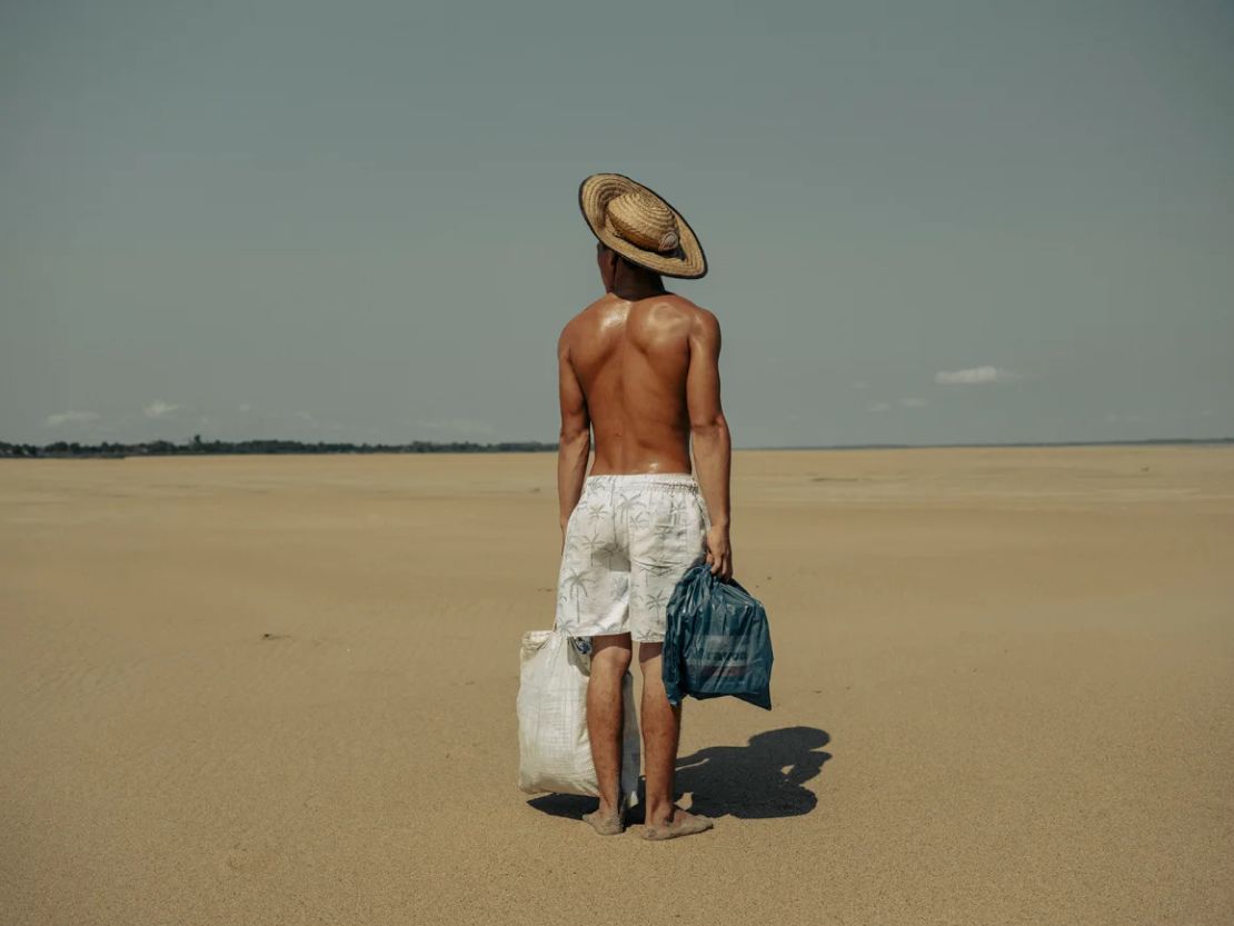 “Sequías en el Amazonas” muestra a un joven caminando por el lecho seco del río Solimoes en Brasil.