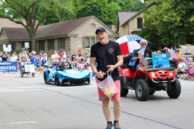 Owner of Chiselled Grape Winery, Allen Naparalla, throws candy and rubber ducks into the crowd at Cedarburg's Fourth of July Parade.