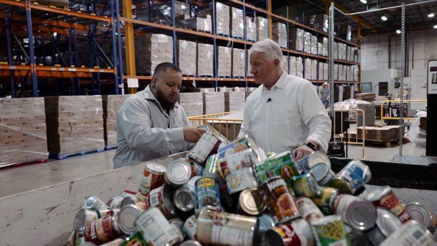 Claudio Rodriguez, vice president for policy and advocacy at the Community Food Bank of Southern Arizona, sorts donated cans with CNN's John King.