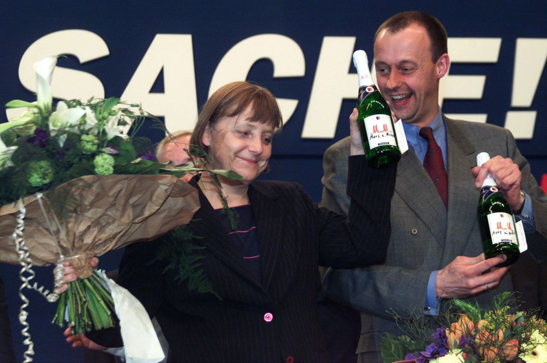 Merz stands with Angela Merkel after she was elected as new party chairwoman in 2000.