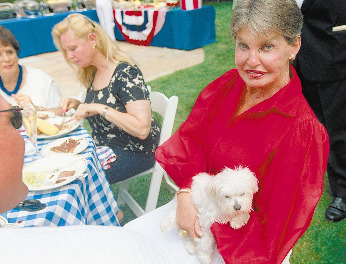 Leona Helmsley, à direita, é mostrada nesta foto de 4 de julho de 2000 com seu cachorro Trouble durante sua comemoração de 80 anos em sua propriedade em Greenwich, Connecticut.