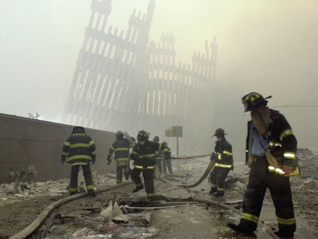 With the skeleton of the World Trade Center in the background, New York City firefighters work amid debris after the terrorist attacks of September 11, 2001.