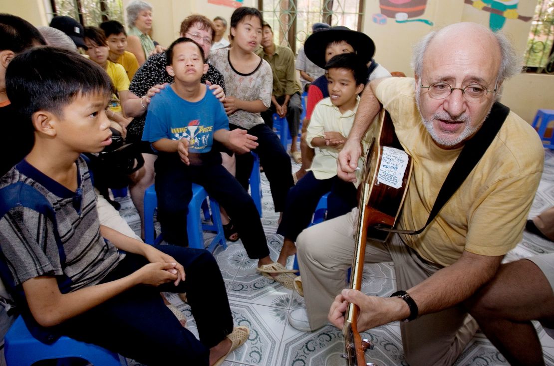 Peter Yarrow (right) sings an anti-war protest song for Vietnamese children affected by Agent Orange at the Friendship Village for Agent Orange victims on the outskirts of Hanoi, Vietnam, in 2005.