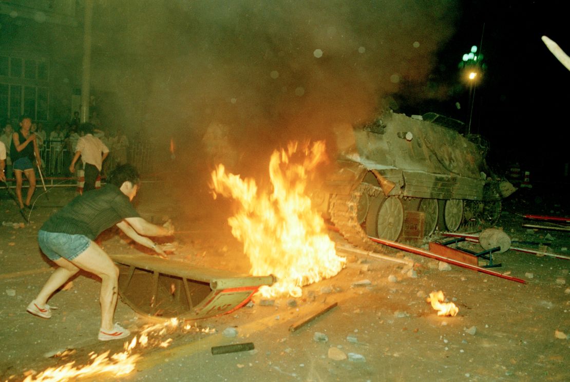 A student protester before a burning armored personnel carrier that rammed through student lines, injuring many during an attack on pro-democracy demonstrators in Tiananmen Square, Beijing, on June 4, 1989.