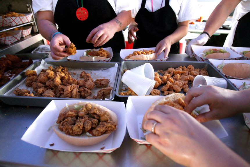 Oyster and shrimp po-boy sandwiches are assembled in Vucinovich's food booth at the New Orleans Jazz and Heritage Festival.