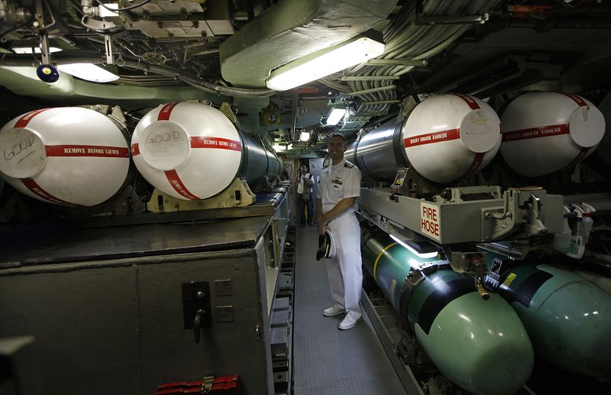 Executive officer Alan Nelson, of the USS Hampton, stands with Tomahawk missiles on board the Los Angeles-class, fast attack submarine on May 17, 2011.