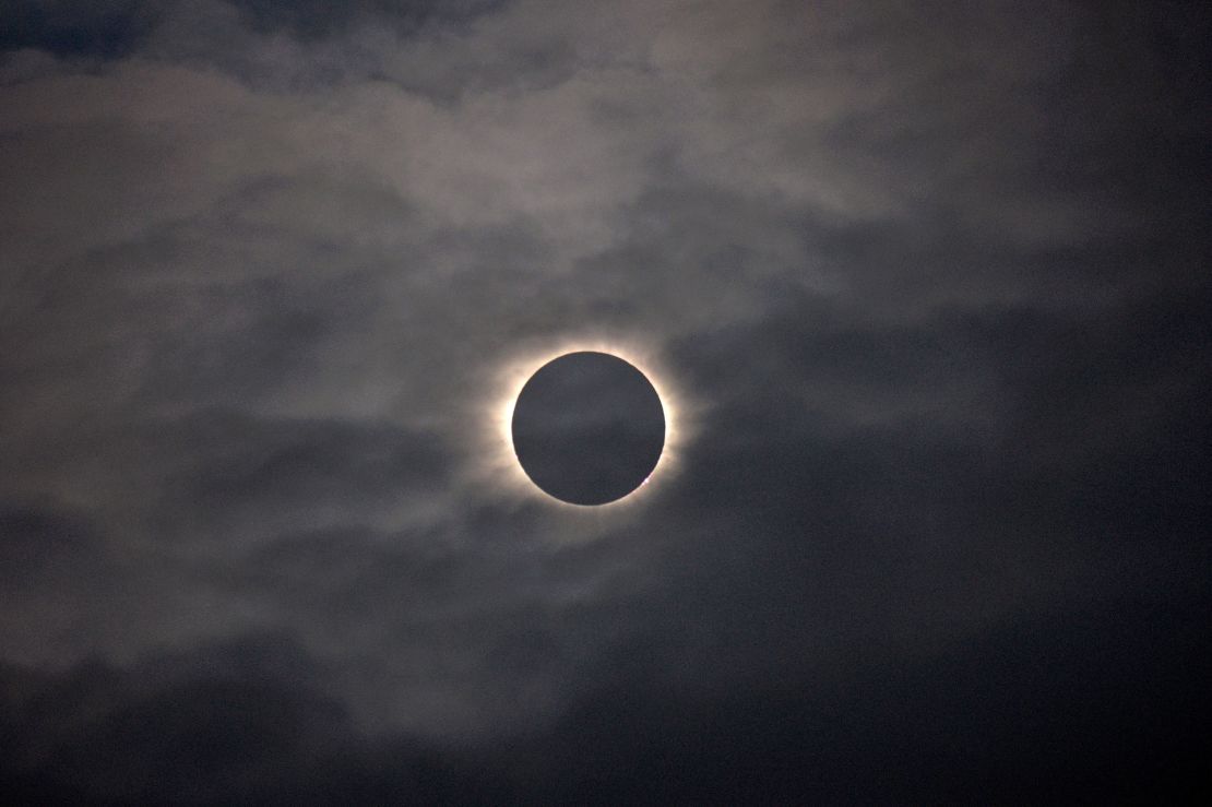 A total solar eclipse is visible through the clouds as seen from the island of Vágar, one of the Faroe Islands, on March 20, 2015.