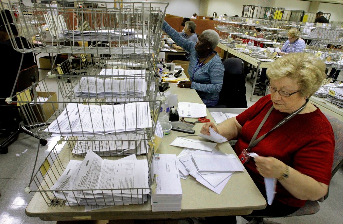 In this April 2012 photo, Illinois Department of Revenue office associate Arline Williams processes 2011 income tax forms in the Document Control and Deposit Division in Springfield, Illinois.