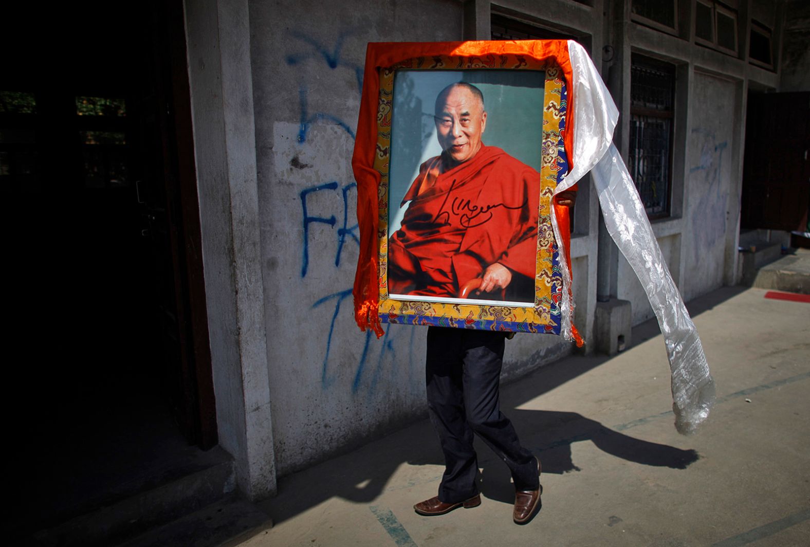 A Tibetan man in Katmandu, Nepal, carries a portrait of the Dalai Lama on April 25, 2012, during an event marking the 23rd birthday of Panchen Lama Gendun Choekyi Nyima, the second-highest Tibetan religious leader.