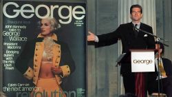 FILE - In this Sept. 7, 1995 file photo, John F. Kennedy Jr., co-founder and editor-in-chief of the politics-as-lifestyle George magazine, unveils the magazine's first cover in New York. A documentary film on John Kennedy Jr.'s life opens Friday, July 22, 2016, in select theaters. It also airs on Spike TV at 9 p.m. EDT on Aug. 1, and a DVD release is set for Aug. 16. (AP Photo/Marty Lederhandler, File)