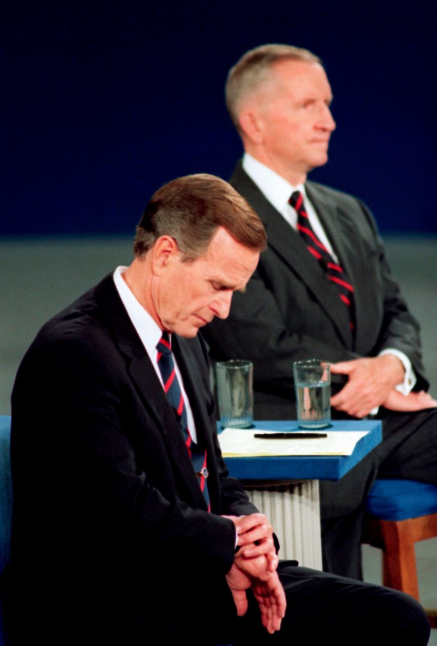Bush looks at his watch during a town hall-style debate with Ross Perot, right, and Bill Clinton in 1992. It became a memorable footnote in his loss to Clinton later that year. Where Clinton was engaged with the audience, <a href="index.php?page=&url=https%3A%2F%2Fwww.cnn.com%2F2012%2F10%2F02%2Fpolitics%2Fdebate-moments-that-mattered%2Findex.html">Bush appeared ready to check out</a>.