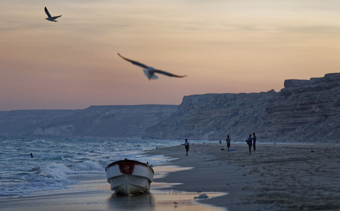 Fishermen stand on the Indian Ocean beach at dusk in Eyl, Puntland, Somalia in March 2017.