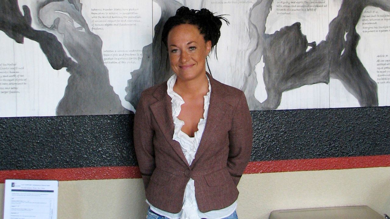 FILE - In this July 24, 2009, file photo, Rachel Dolezal, a leader of the Human Rights Education Institute, stands in front of a mural she painted at the institute's offices in Coeur d'Alene, Idaho. Days after defending its decision to have Dolezal, the white woman who led others to believe she was black, take part in the Baltimore Book Festival, organizers say the former head of the Spokane chapter of the NAACP has been disinvited, Tuesday, May 30, 2017. (AP Photo/Nicholas K. Geranios, File)