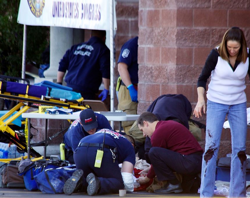 Emergency personnel attend to a victim on January 8, 2011, outside the Arizona shopping center where Rep. Gabrielle Giffords and others were shot.