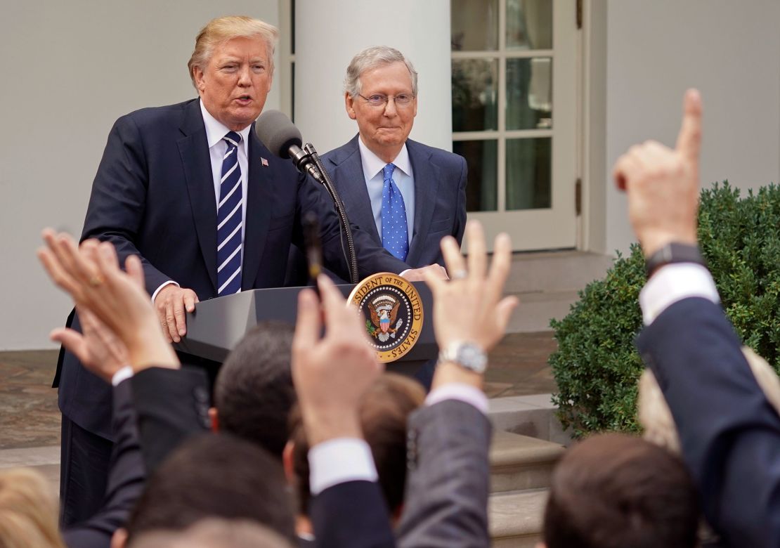 A journalist raises his hand as he waits to ask questions of President Donald Trump and Senate Majority Leader Mitch McConnell in 2017.