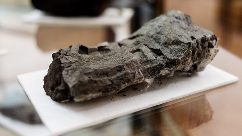 An ancient scroll, completely covered in blazing-hot volcanic material, is displayed at the Naples' National Library, Italy, Jan. 20, 2015. Scientists have succeeded in reading parts of an ancient scroll that was buried in a volcanic eruption almost 2,000 years ago, holding out the promise that the world's oldest surviving library may one day reveal all of its secrets. The scroll is among hundreds retrieved from the remains of a lavish villa at Herculaneum, which along with Pompeii was one of several Roman towns that were destroyed when Mt. Vesuvius erupted in A.D. 79. (AP Photo/Salvatore Laporta)
