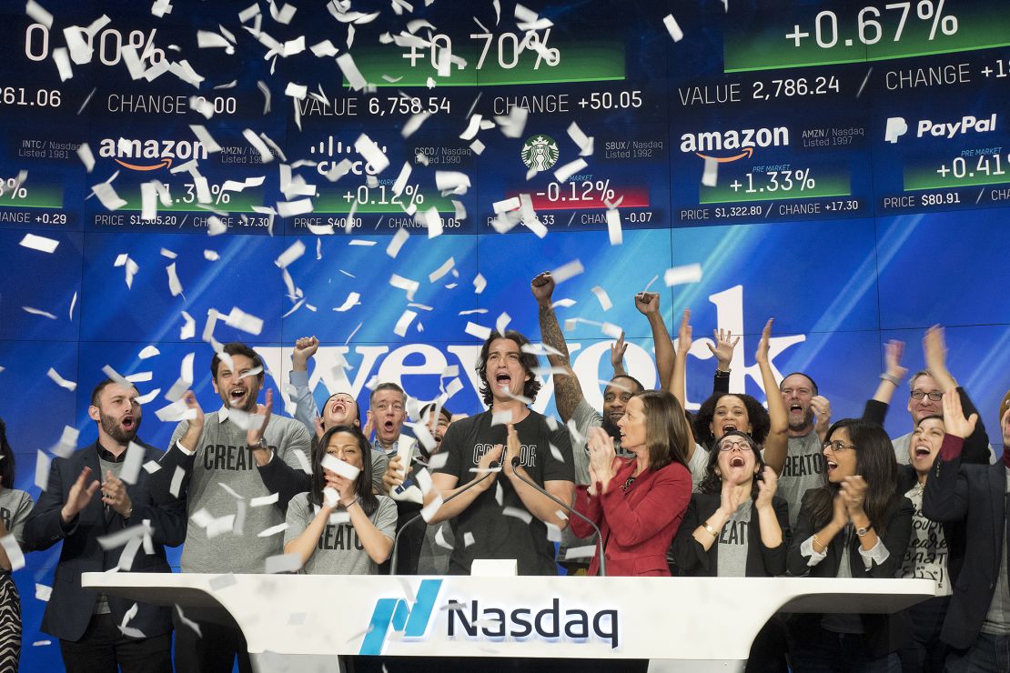 Adam Neumann, center, co-founder and CEO of WeWork, attends the opening bell ceremony at Nasdaq, Tuesday, Jan. 16, 2018, in New York.