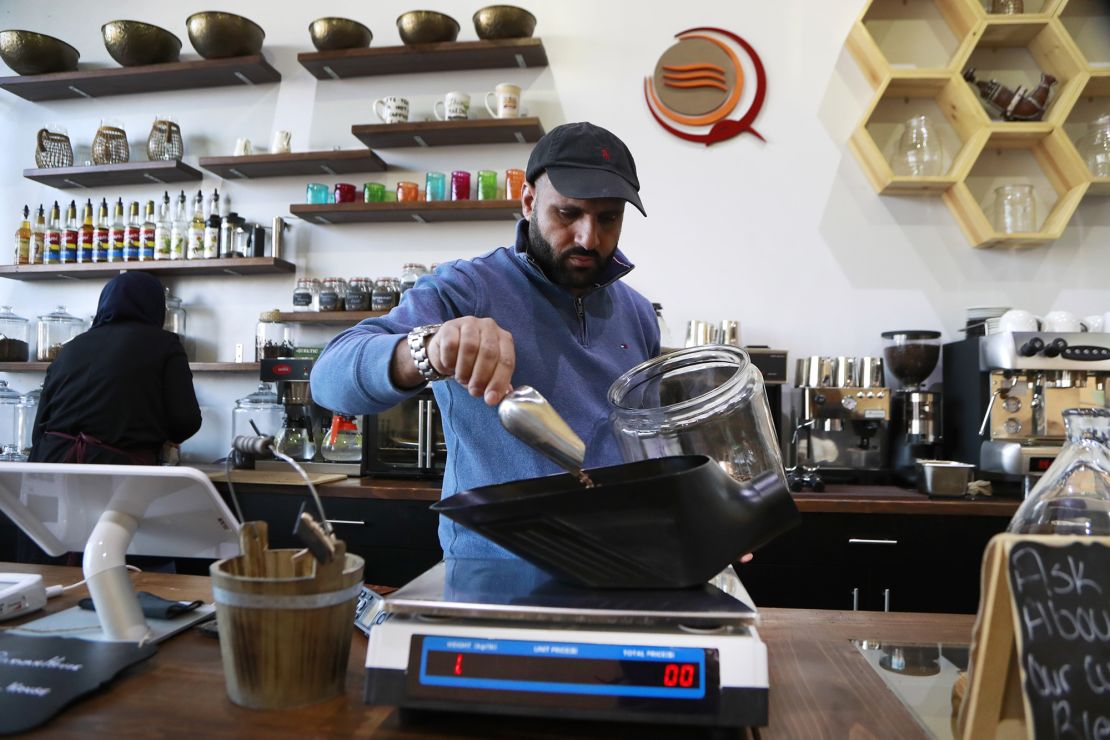 In this Jan. 9, 2018, photo, Ibrahim Alhasbani, owner of Qahwah House, a cafe that serves coffee made from beans harvested on his family's farm in Yemen's mountains, measures coffee beans in Dearborn, Mich.