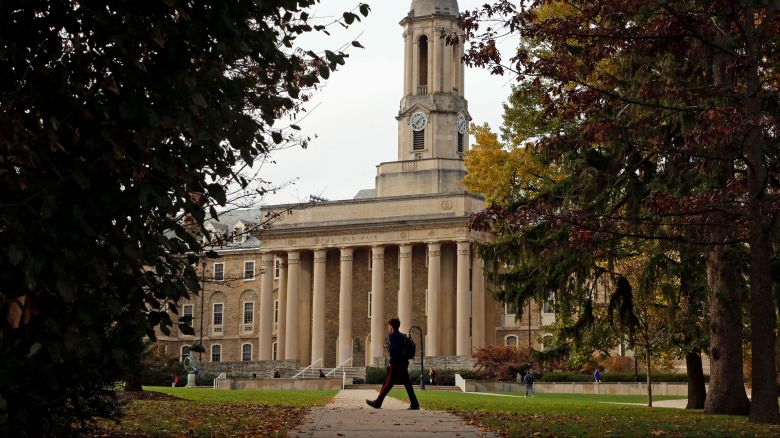 In this November 9, 2017, file photo people walk by Old Main on the Penn State University main campus in State College, Pennsylvania.