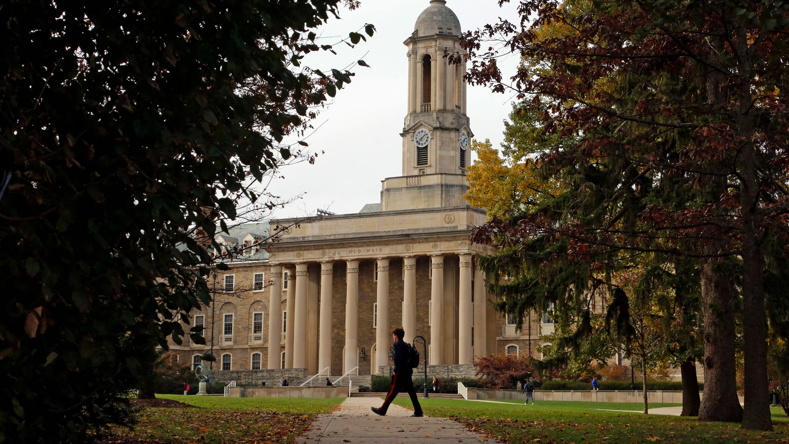 In this November 9, 2017, file photo, people walk by Old Main on the Penn State University main campus.