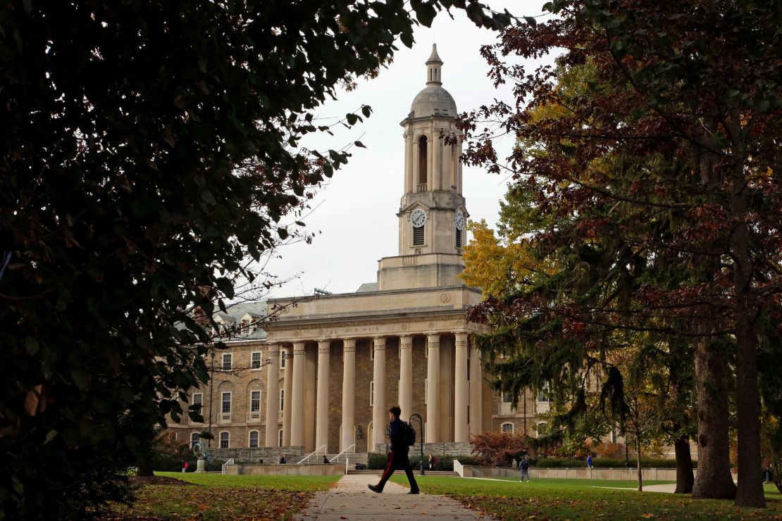 As pessoas passam pela Old Main, no campus principal da Penn State University.