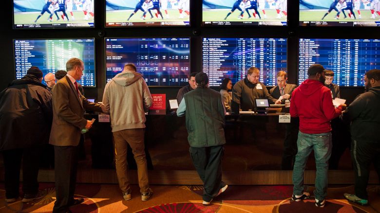 FILE - In this Thursday, Dec. 13, 2018, file photo, gamblers place bets in the temporary sports betting area at the SugarHouse Casino in Philadelphia. About six in 10 Americans want betting on professional sports events to be legal in their state, but fewer feel that way about college athletics, according to a new poll conducted by The Associated Press-NORC Center for Public Affairs Research released Wednesday, March 20, 2019.  The poll finds 42 percent favor legal betting on college sports. (AP Photo/Matt Rourke, File)