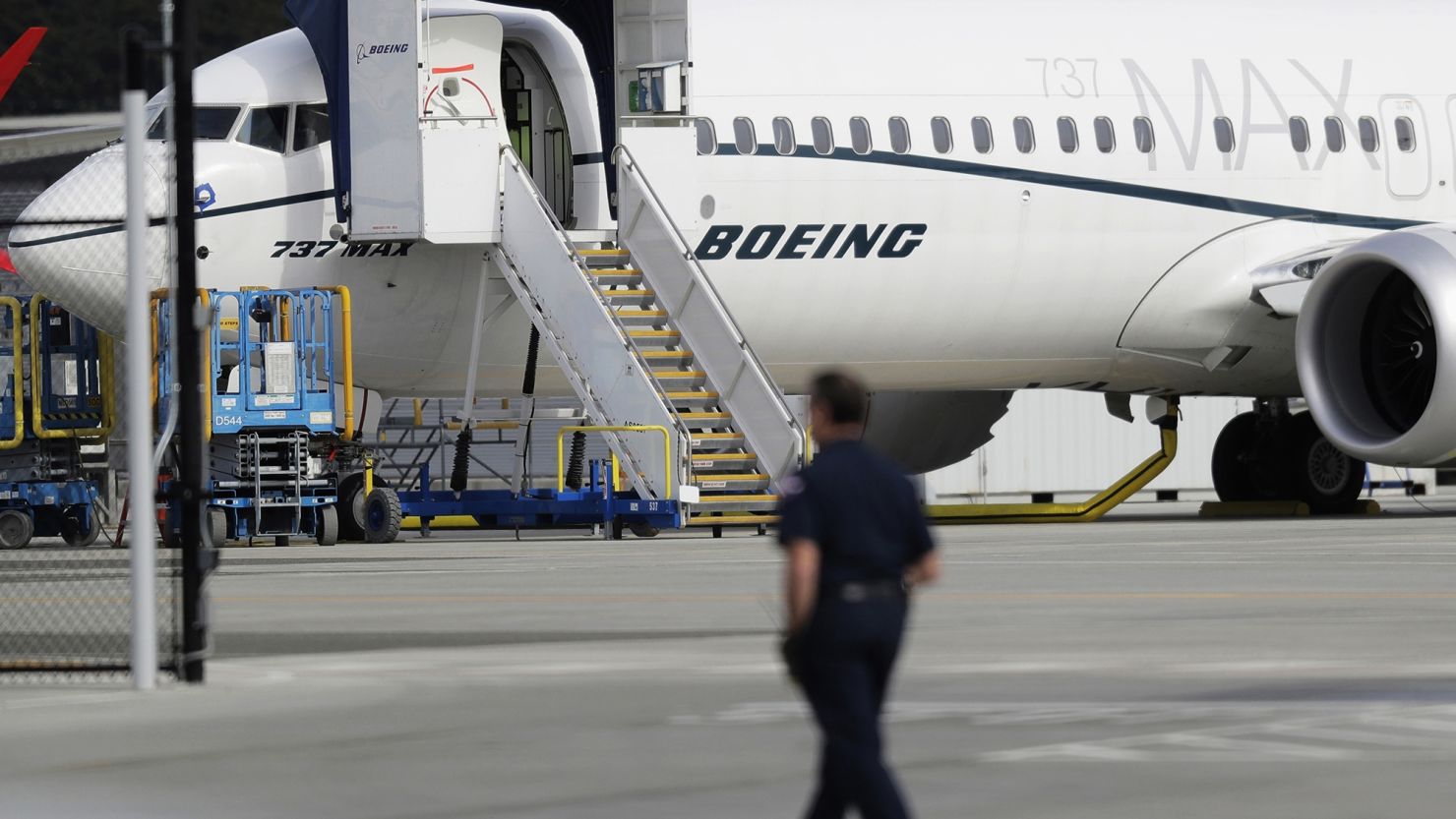 A worker walks next to a Boeing 737 MAX 8 airplane parked at Boeing Field in Seattle, WA, on March 14, 2019.