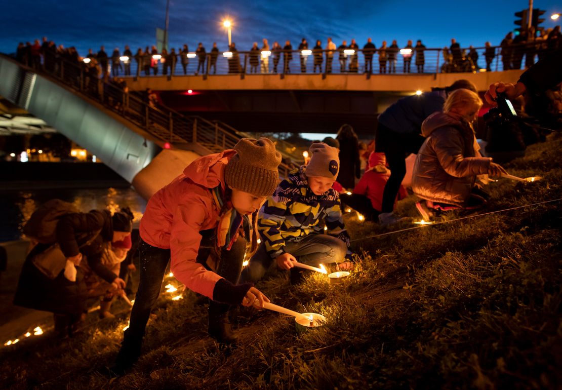 People participate in rituals during a fall equinox celebration on an embankment of the Neris River near King Mindaugas' Bridge in Vilnius, Lithuania, in 2019.