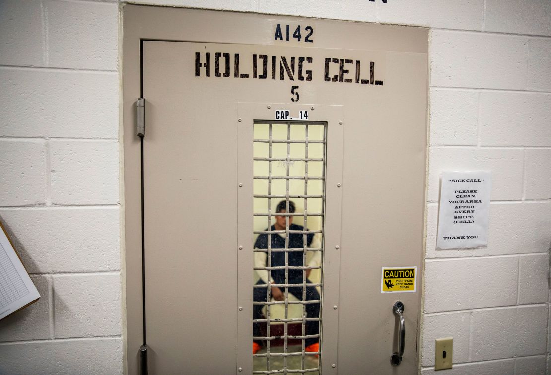 A detainee sits in a holding cell at the Stewart Detention Center in Lumpkin, Georgia.