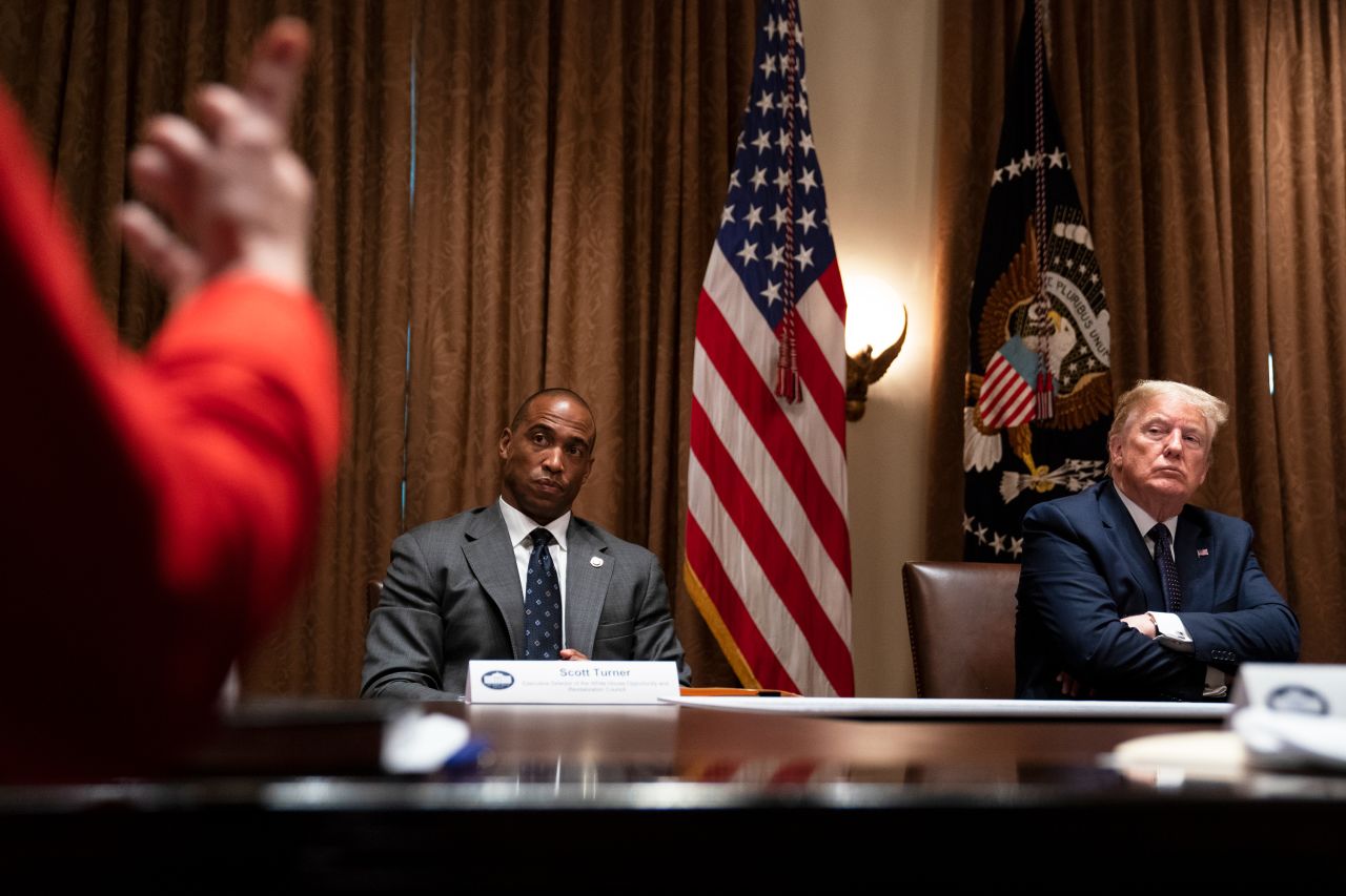 Scott Turner and Donald Trump listen during a meeting at the White House, in Washington, DC, on May 18, 2020.