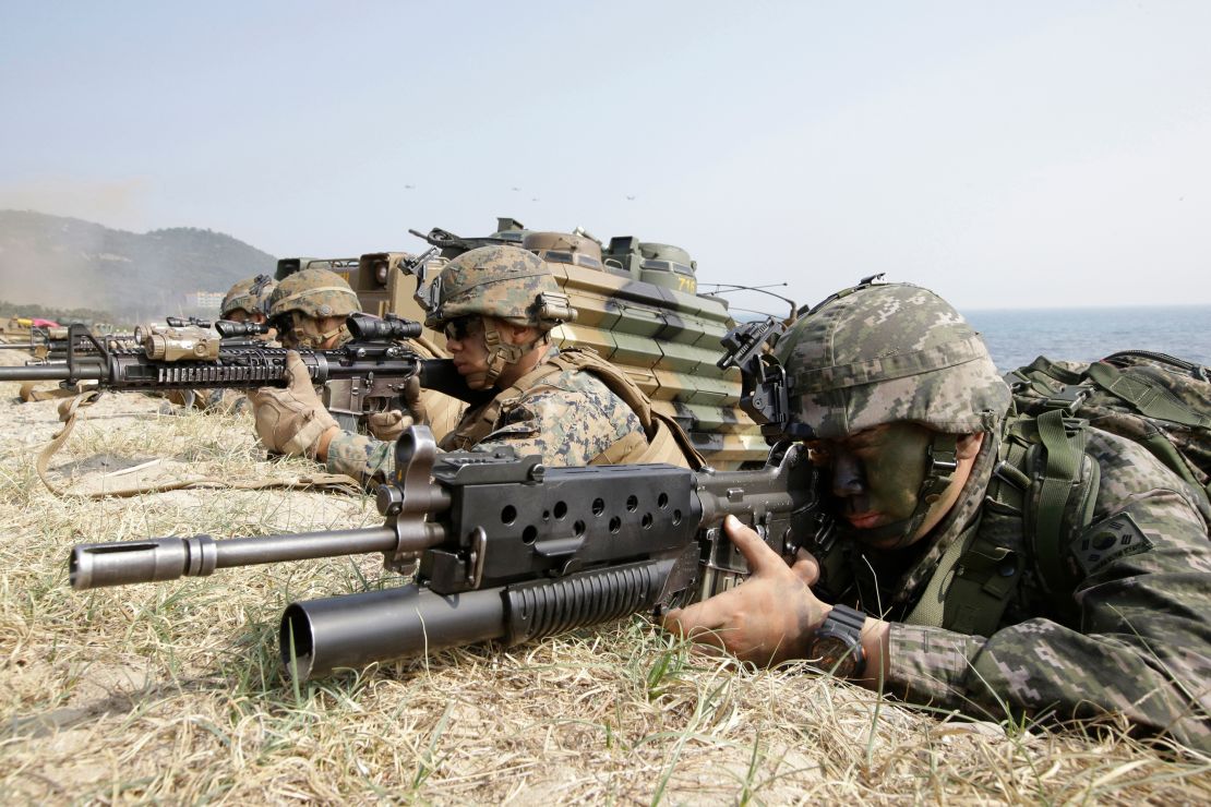 Marines of South Korea, right, and the US, aim their weapons near amphibious assault vehicles during a US and South Korea joint landing military exercise in Pohang, South Korea, on March 30, 2015.