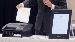 FILE - In this Thursday, Aug. 30, 2018 file photo, a Smartmatic representative demonstrates his company's system which has scanners and touch screens with printout options at a meeting of the Secure, Accessible & Fair Elections Commission in Grovetown, Ga. Antonio Mugica, CEO of Smartmatic, the electronic voting company being targeted by allies of Donald Trump, said baseless claims that it helped flip the 2020 election for Joe Biden threatens to undermine Americans’ faith in democracy and the company is threatening legal action unless Fox News, Rudy Giuliani and other Trump allies fully retract baseless claims. (Bob Andres/Atlanta Journal-Constitution via AP, File)