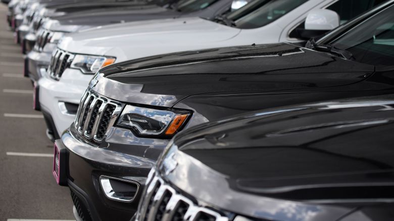 In this Sunday, June 27, 2021, photograph, a handful of unsold 2021 Grand Cherokee sports-utility vehicles sits in a near-empty lot at a Jeep dealership in Littleton, Colo. A microchip shortage for vehicles created by factories closed by the coronavirus has combined with pent-up demand, also fostered by the virus, to leave dealers' lots devoid of new stock during a typically strong time of the year for sales. (AP Photo/David Zalubowski)
