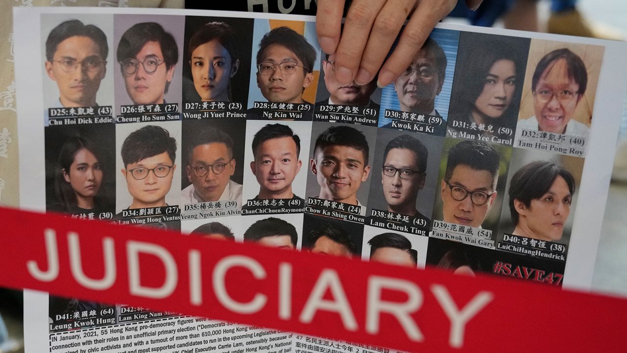 A supporter holds a placard with the photos of some of the 47 pro-democracy defendants outside a court in Hong Kong, on July 8, 2021.