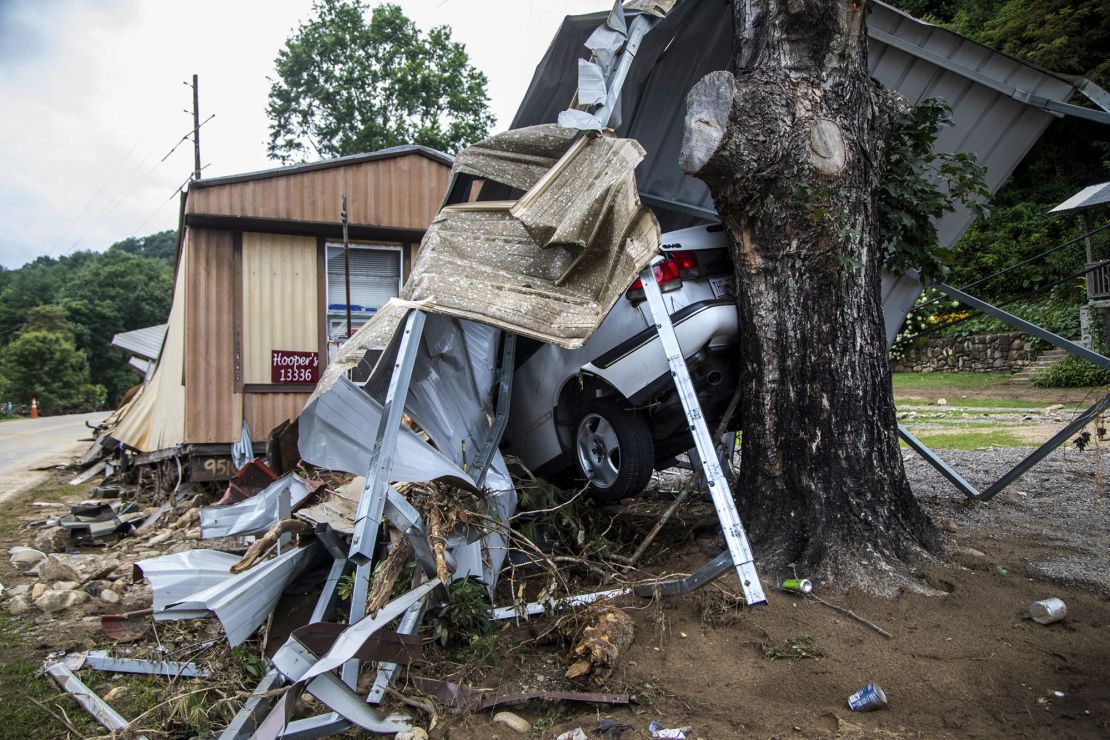 The wreckage of a mobile home and a car are smashed into a tree on the East Fork Pigeon River on August 20, 2021, following Tropical Storm Fred in Cruso, North Carolina.