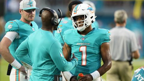 Tua Tagovailoa (right) talks to Brian Flores (left) during a Miami Dolphins preseason game against the Atlanta Falcons on August 21, 2021.