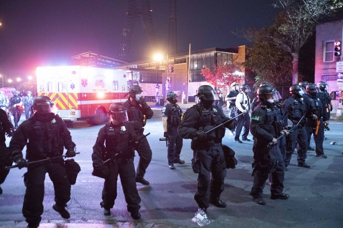 In this October 28, 2020, file photo, Washington Metropolitan Police Department police officers push back demonstrators outside of the fourth district police station in Washington after an officer was indicted on a murder charge for his role in a fatal vehicle accident during a police chase that has sparked two days of protests and clashes.