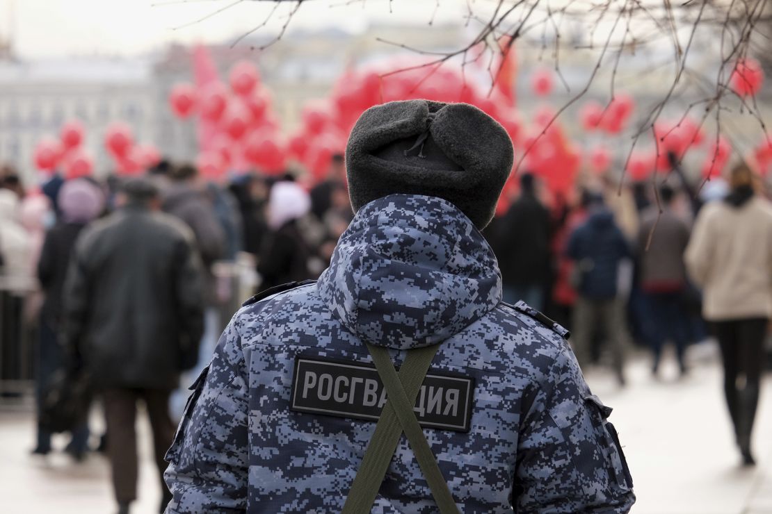 A Rosgvardia serviceman watches a parade in Russia. The force, which reports directly to Russian President Vladimir Putin, has been deployed to occupied Ukraine to quash protests and opposition.