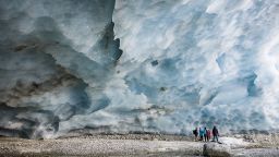 Hikers visit an ice cave formed at the end section of the Zinal glacier, above the alpine village of Zinal, Switzerland, Saturday, Nov. 13, 2021.(Valentin Flauraud/Keystone via AP)