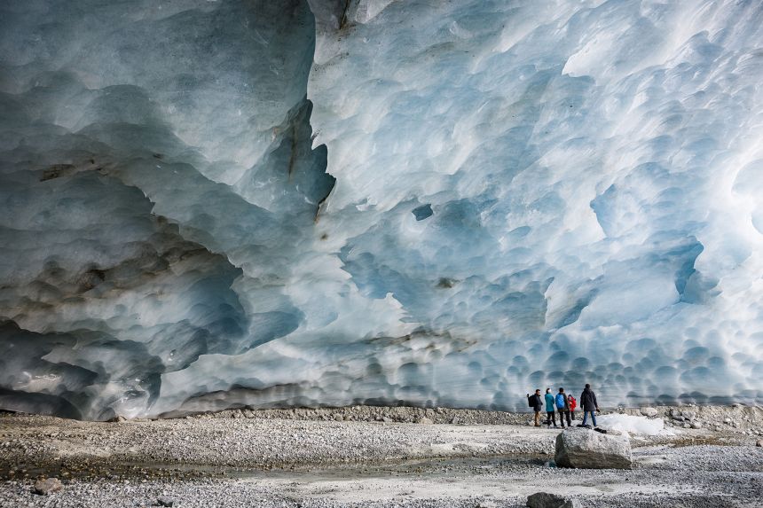 Hikers visit an ice cave formed at the end section of the Zinal glacier in Switzerland.